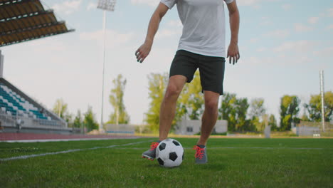 A-soccer-player-at-the-stadium-demonstrates-dribbling-with-a-soccer-ball-while-leading-a-sword-while-running.-Excellent-skill-of-a-football-player-and-ball-control
